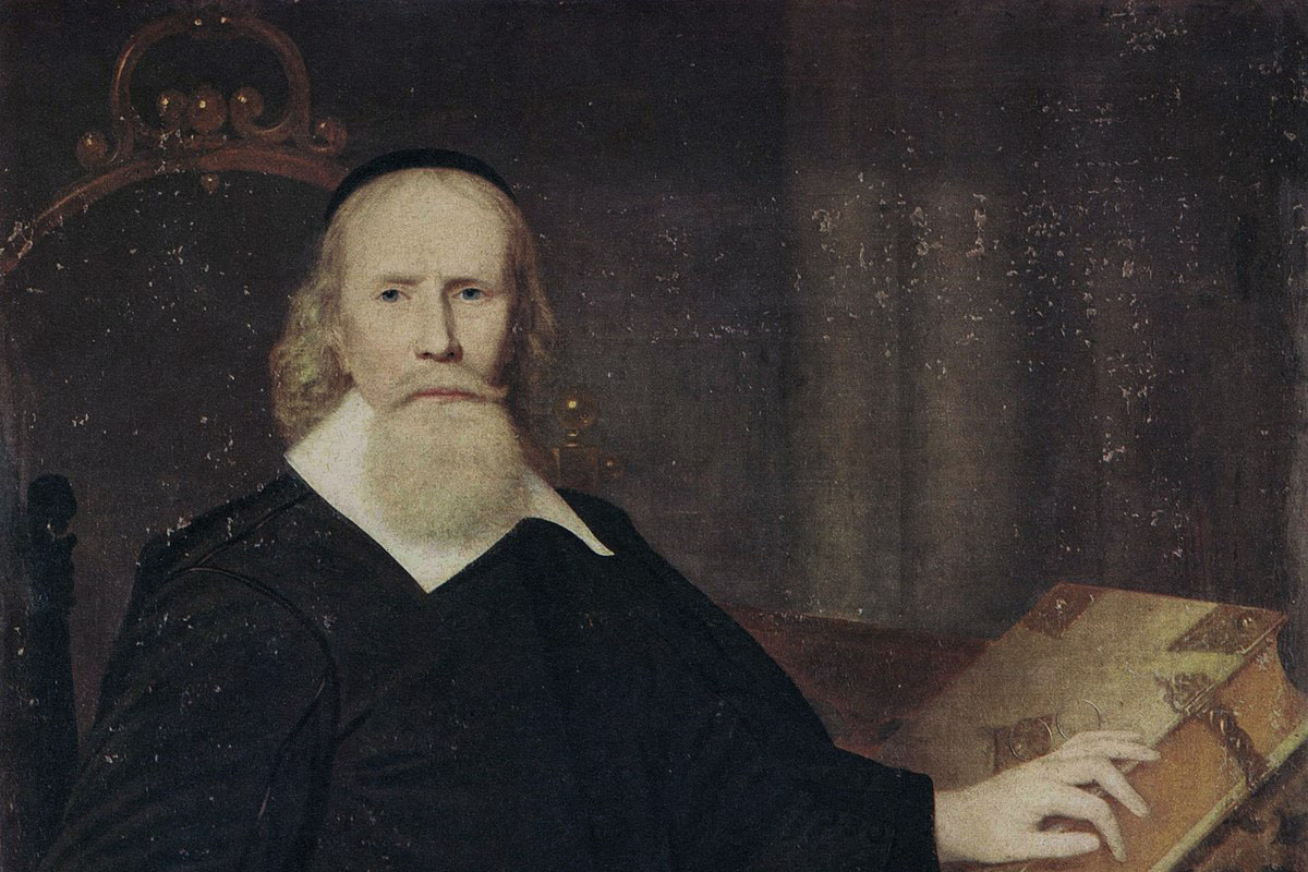 Clarke in a black robe and long beard